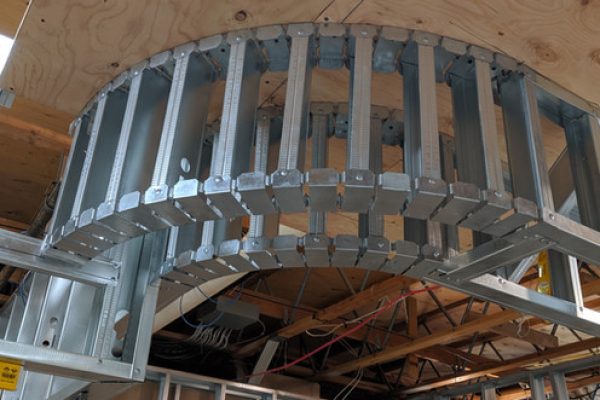 A metal structure being assembled in a room, with tools and equipment scattered around.