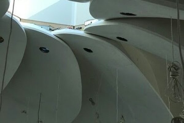 A white ceiling with numerous hanging ropes, creating a unique and intricate pattern.